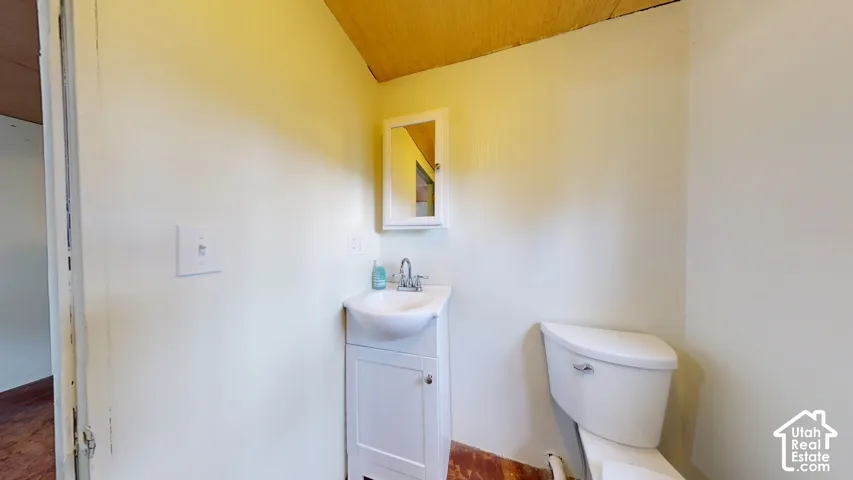 Vanity with integrated sink, wall-mounted medicine cabinet, and a two-piece toilet