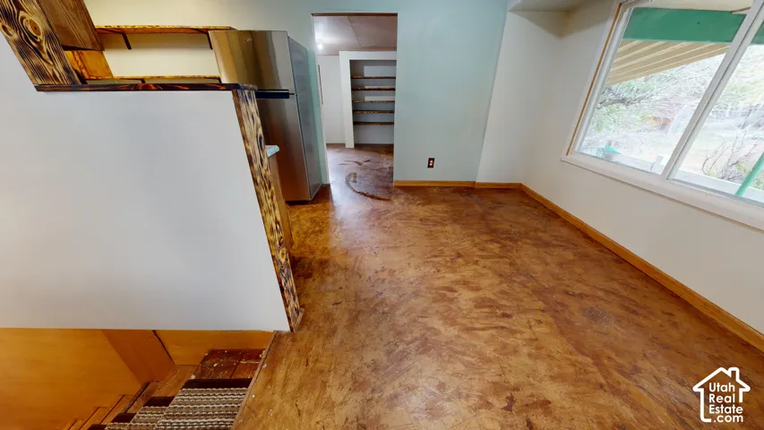 Wood-finish flooring, stainless steel refrigerator, and built-in shelving