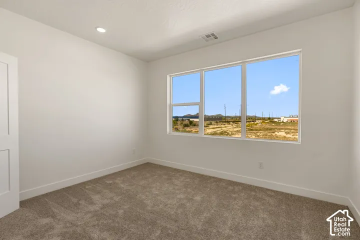 Wall-to-wall carpeting, recessed ceiling light, white paneled door, and expansive window with mountain scenery
