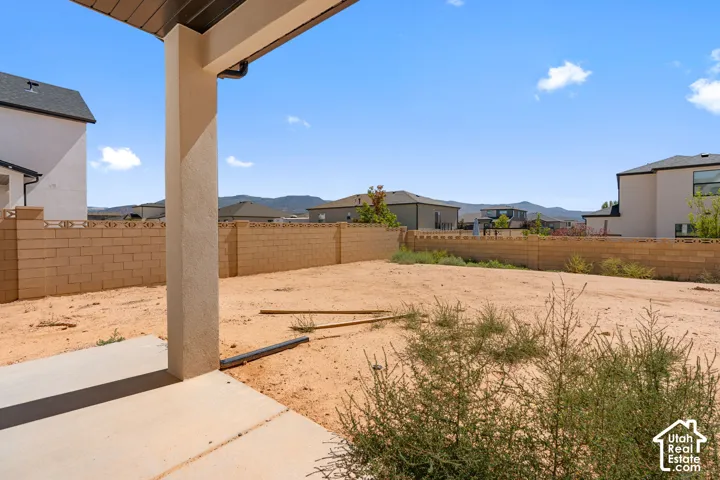 Spacious backyard with a concrete patio, covered patio structure, and block perimeter fencing