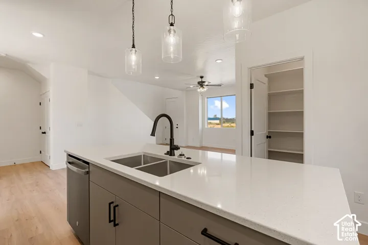 Kitchen island with a double basin sink, matte black faucet, and pendant lighting