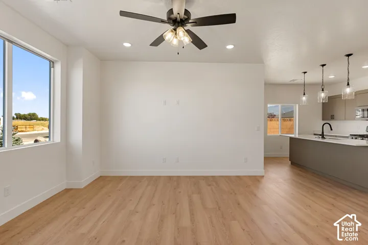 Wood-finish flooring throughout, complemented by a contemporary ceiling fan with integrated lighting