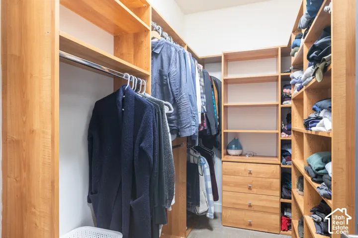 Custom wood-finish shelving, built-in dresser, and hanging rods