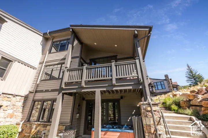 Multi-level exterior with siding, stone detailing, and a covered balcony