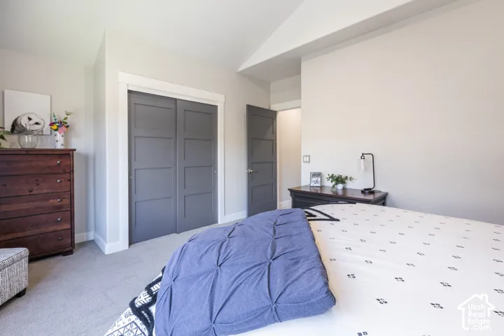 Neutral wall paint with white trim, gray paneled closet doors, and light-colored carpeting