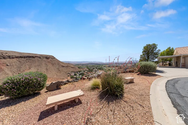 Elevated desert landscaping featuring low-maintenance shrubs and a concrete bench