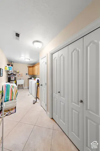 Tiled flooring extending throughout, utility sink, and built-in cabinetry