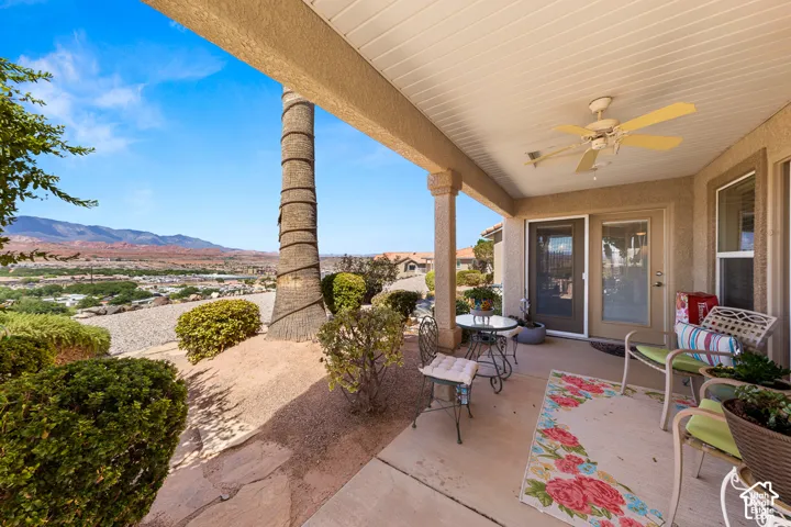 Covered patio with a ceiling fan, dual sliding glass door, and a permanent exterior column