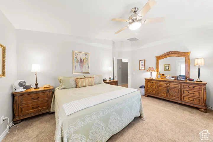Recessed ceiling with a central fan light fixture, light neutral wall paint, and neutral carpet flooring
