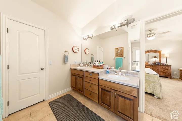 Double vanity with wood-finish cabinetry, integrated sinks, and polished chrome fixtures