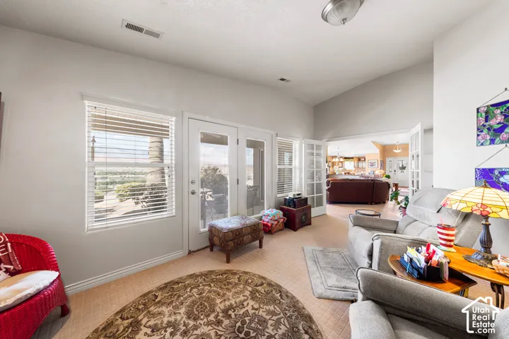 French doors leading to an outdoor space, high ceilings, large windows, and an open concept layout