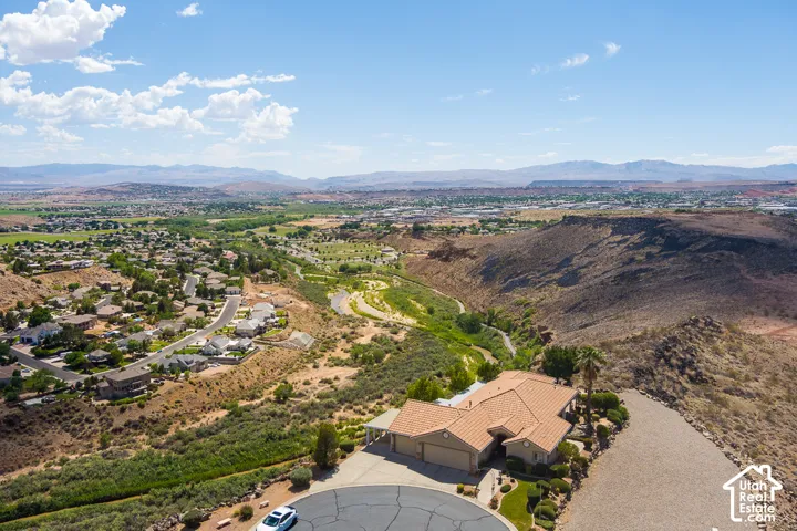 Terracotta tile roof, multi-car garage, mature landscaping, and a circular driveway