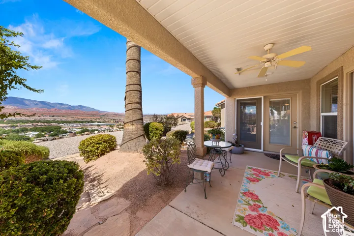 Covered patio with a ceiling fan, dual sliding glass door, and a permanent exterior column