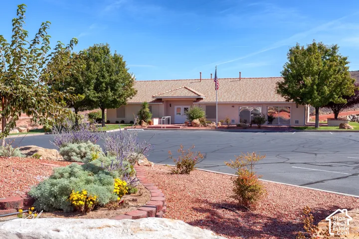 Expansive paved parking lot with a single-story building featuring a tile roof
