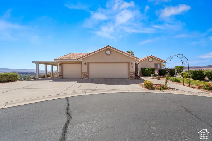Stucco exterior with a tile roof, two-car garage, and an attached carport