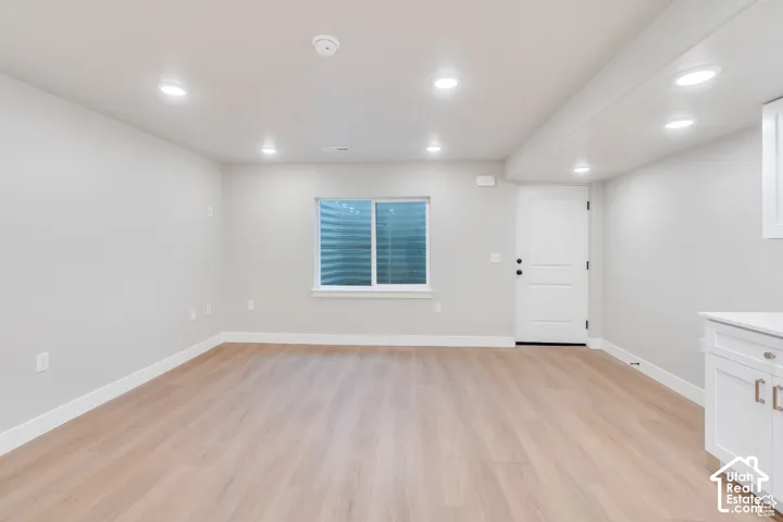 Recessed lighting throughout, wood-finish flooring, and white trim