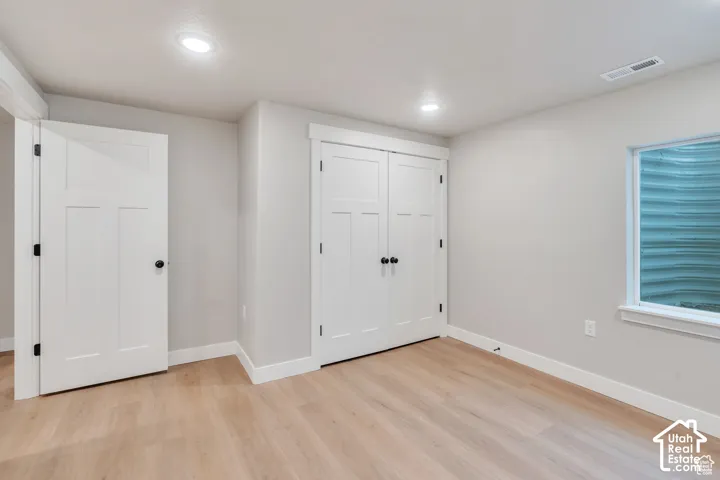 Light wood-finish flooring, recessed lighting, and white trim