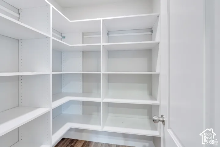 Custom shelving system with adjustable white shelves and wood-finish flooring