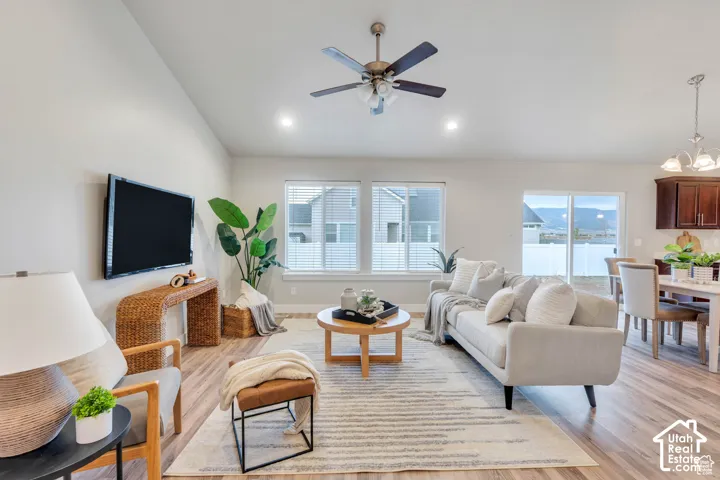 Vaulted ceiling with a ceiling fan, wood-finish flooring, recessed lighting, and sliding glass doors