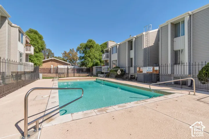 Community swimming pool with a concrete surround and metal access rails
