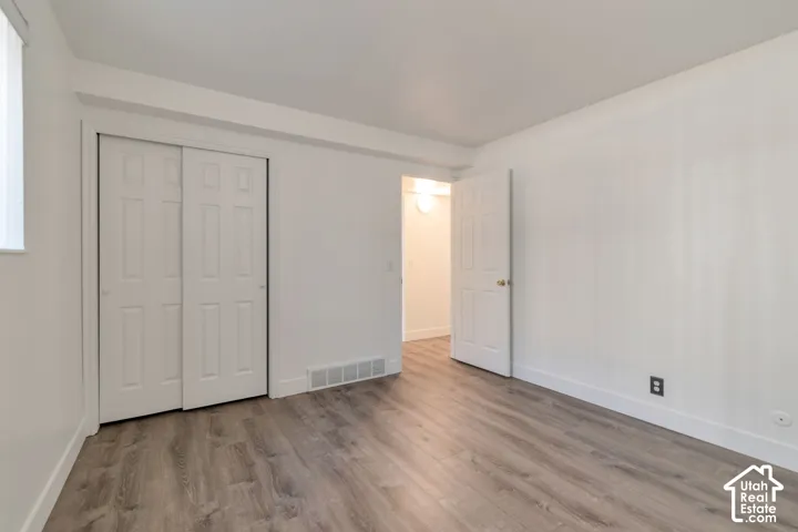 Wood-finish flooring, white walls, and a sliding two-panel closet door
