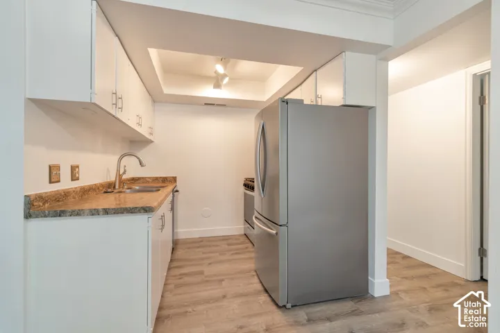 Kitchen featuring white cabinetry, granite-finish countertops, and wood-finish flooring