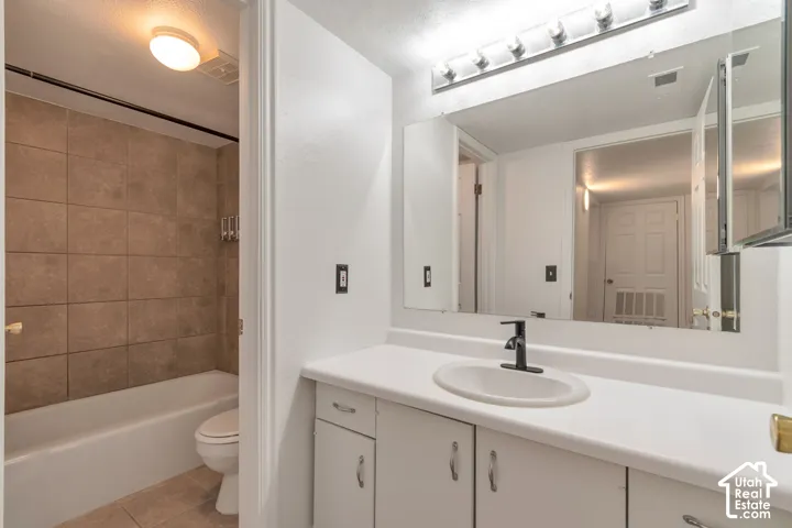 Bathroom featuring a white vanity with an undermount sink, black-finish faucet, and a large wall-mounted mirror