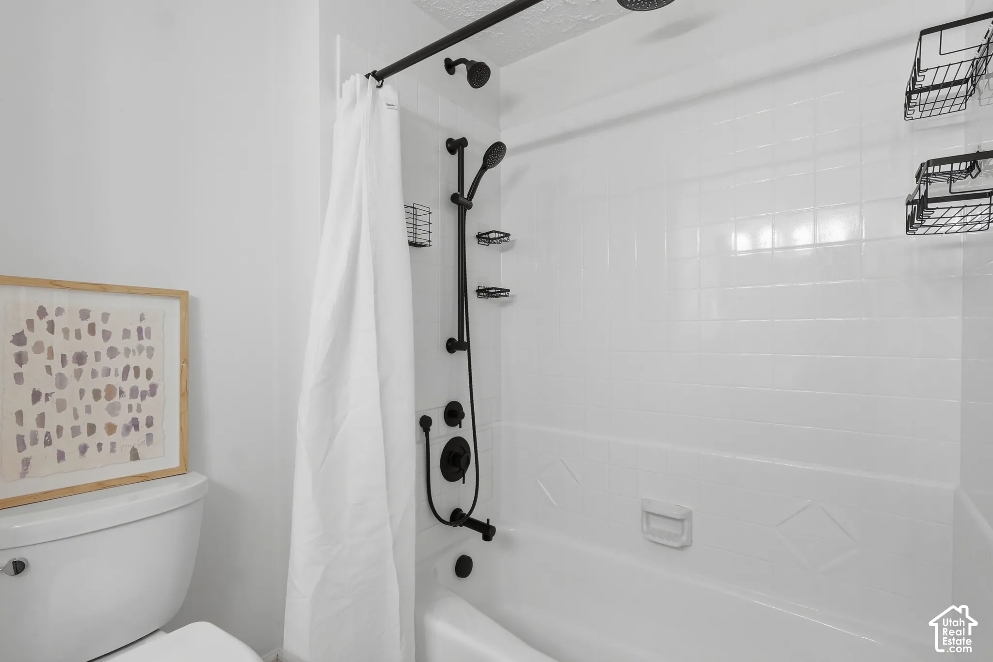 Built-in tub with white tile surround, featuring matte black shower fixtures including a rain shower head and handheld sprayer