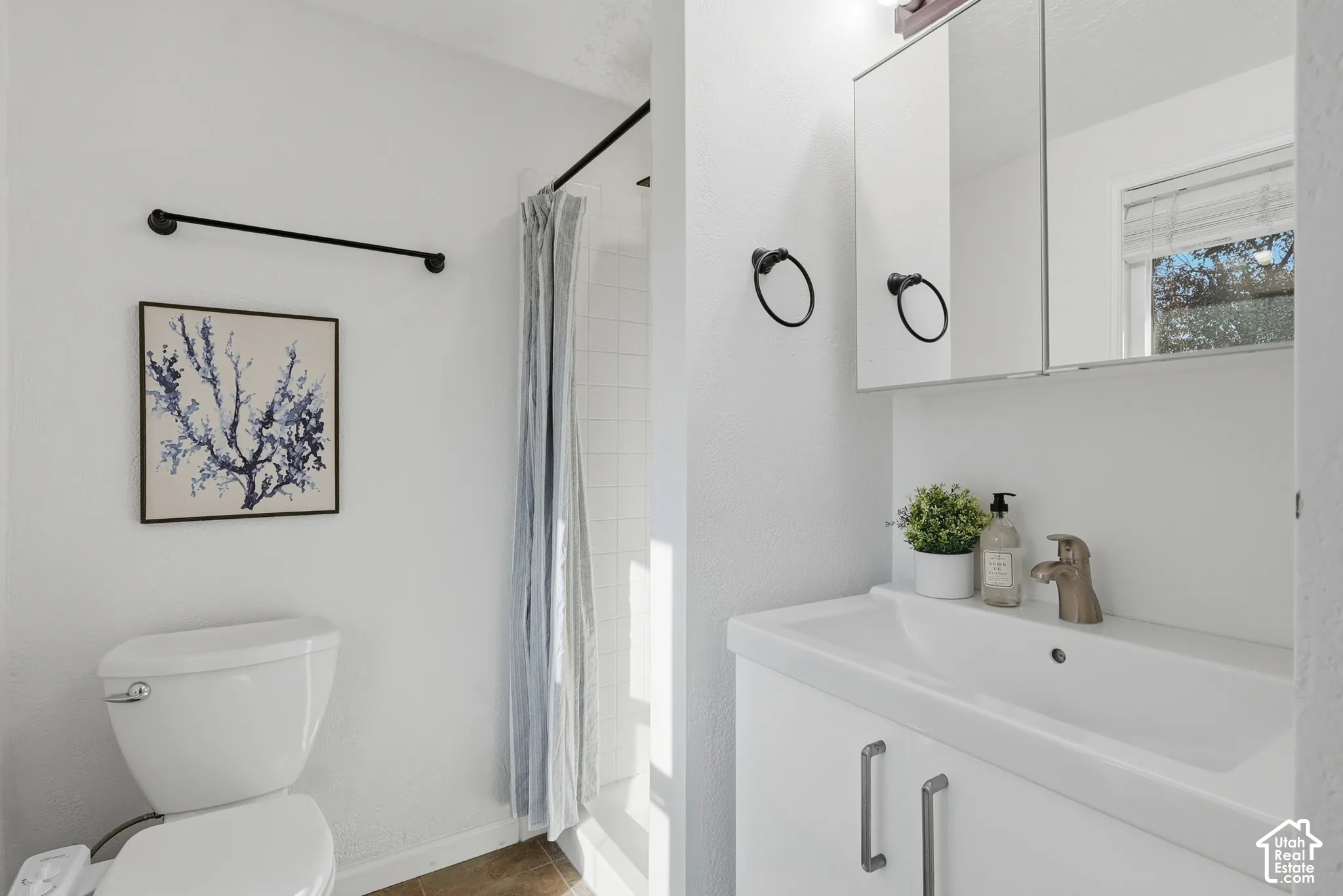 White vanity with integrated sink, brushed nickel faucet, and coordinating hardware