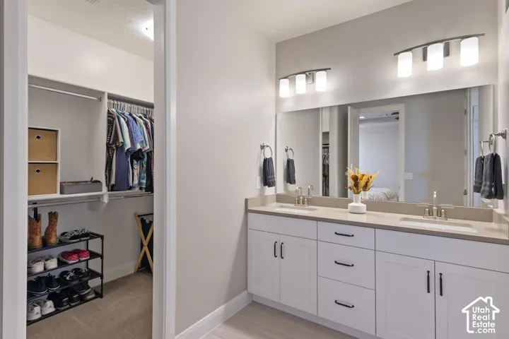 Dual vanity with undermount sinks, stone countertops, and extended mirror