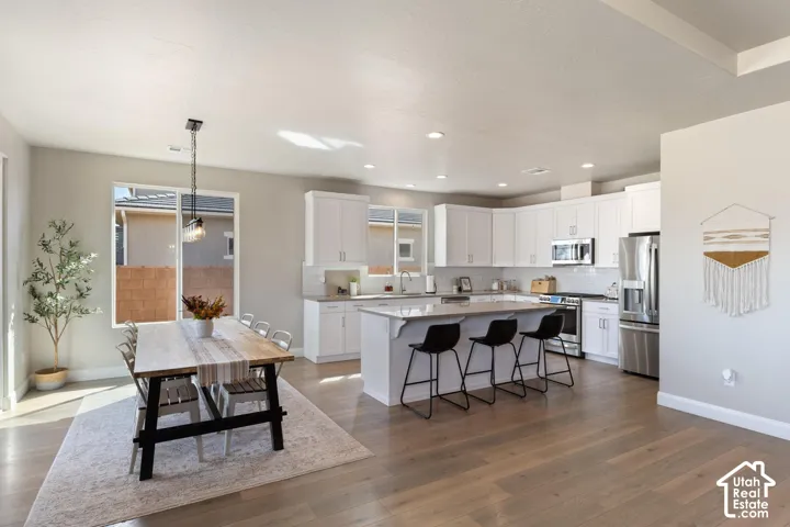 Open-concept kitchen and dining area featuring wood-finish flooring
