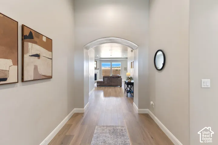 Archway entry with wood-finish flooring and neutral wall tones