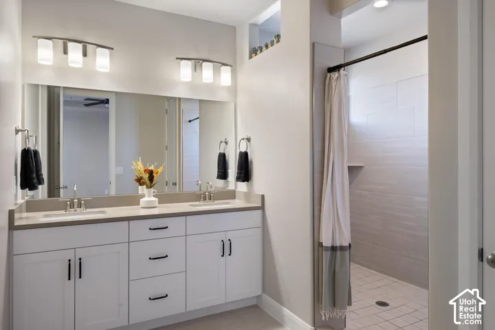 Spa-inspired primary bathroom featuring a dual-sink vanity with soft-close cabinetry, brushed nickel hardware, and a quartz countertop