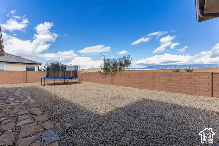 Backyard featuring a stone paver patio, gravel landscaping, and a perimeter block wall