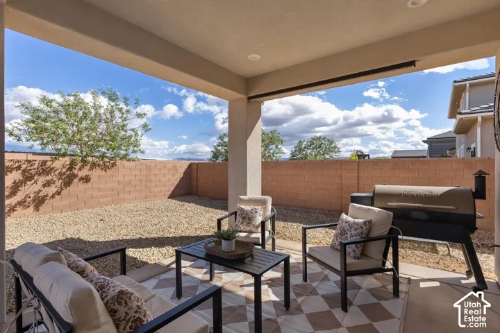 Covered patio with a concrete surface, enclosed by a block wall