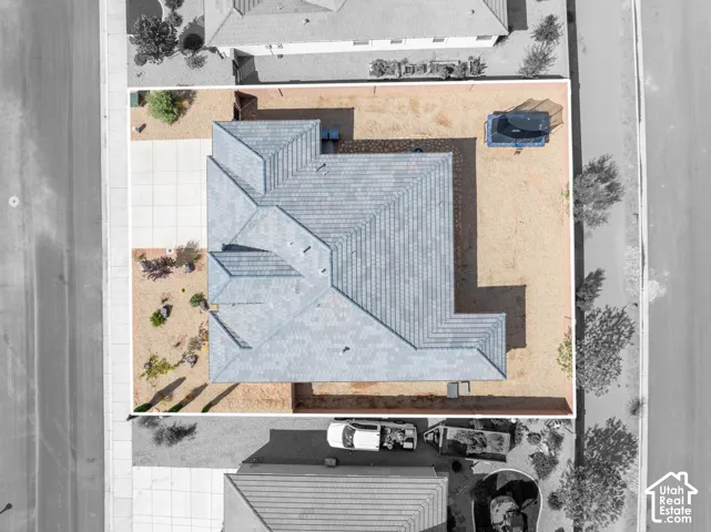 Gabled roofline, concrete driveway, xeriscaped front yard, and expansive backyard space