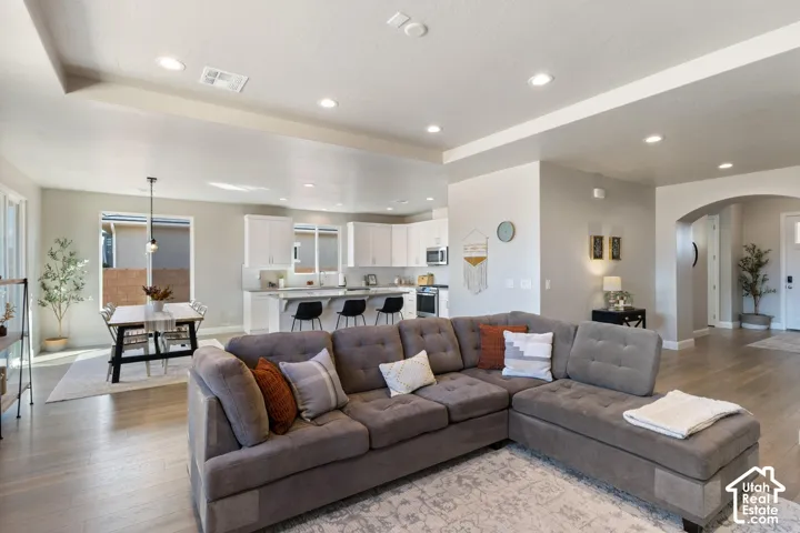Recessed lighting, wood-finish flooring, and arched entryway