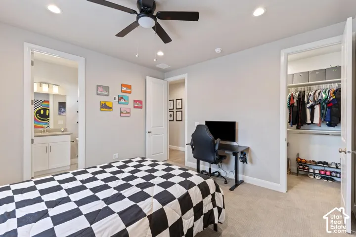 Recessed lighting, ceiling fan, carpet flooring, built-in closet shelving, and a vanity with a rectangular basin