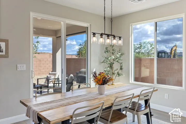 Recessed lighting, wood-finish flooring, sliding glass door, modern linear chandelier, and a large window