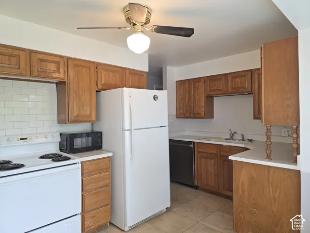 Kitchen featuring wood cabinetry, white tile backsplash, tile flooring, and integrated ceiling fan light fixture
