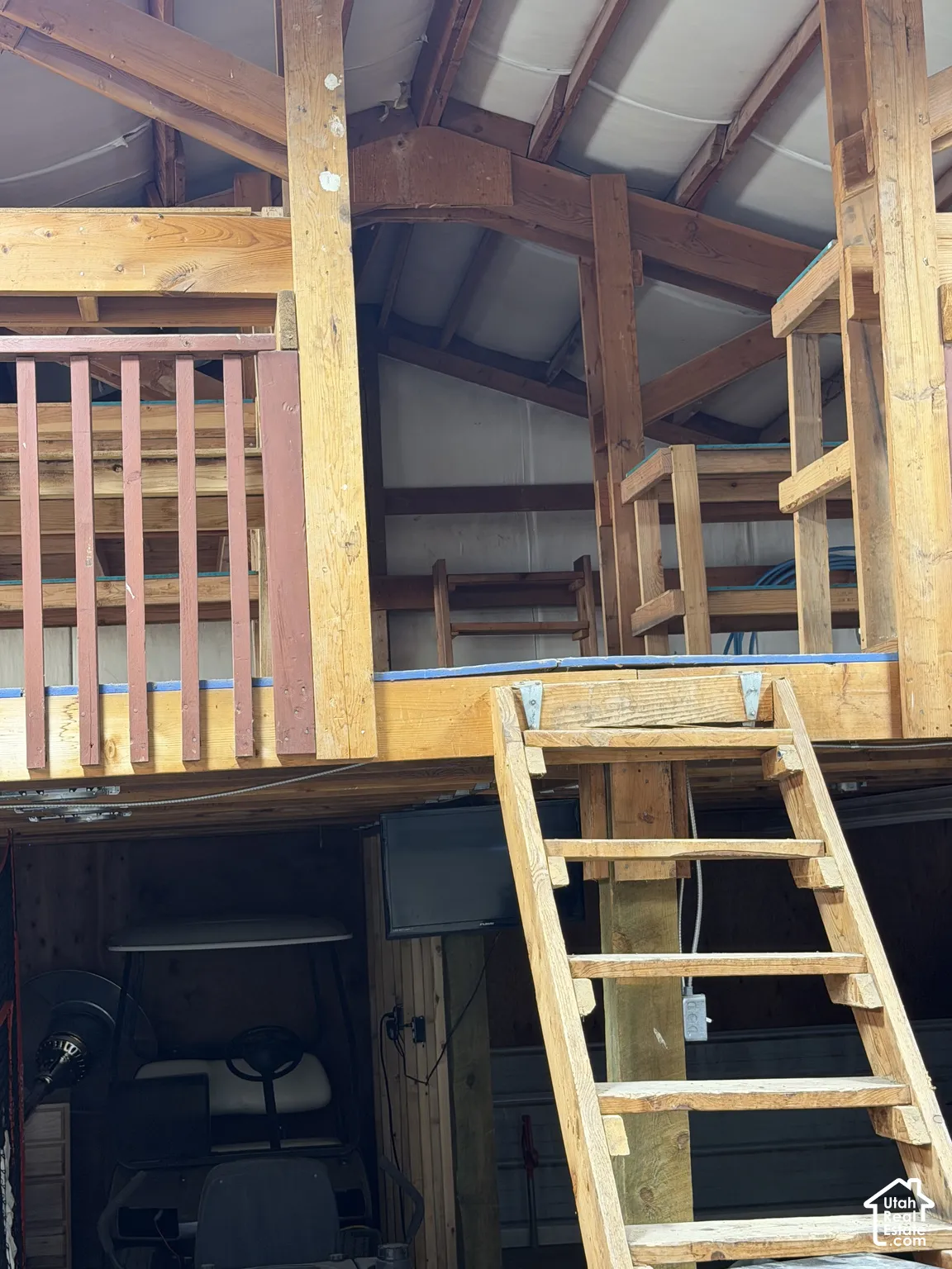 Upper-level loft with wood railing, accessed by a wood ladder