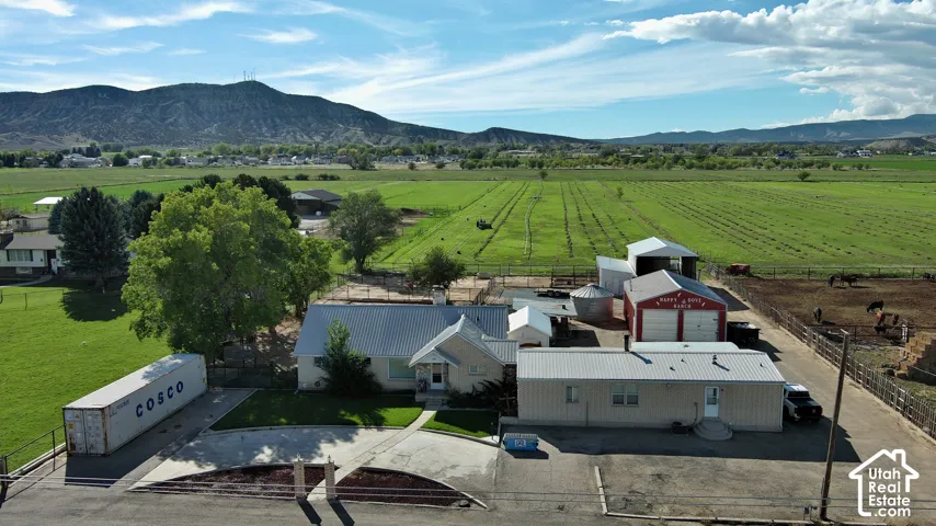 Expansive property featuring multiple outbuildings, fenced animal enclosures, and agricultural fields