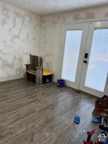 Wood-finish flooring with a durable surface, paired with a double French door featuring frosted glass panels
