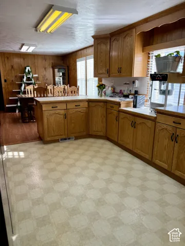 Kitchen featuring wood-finish cabinetry, patterned flooring, and ample counter space