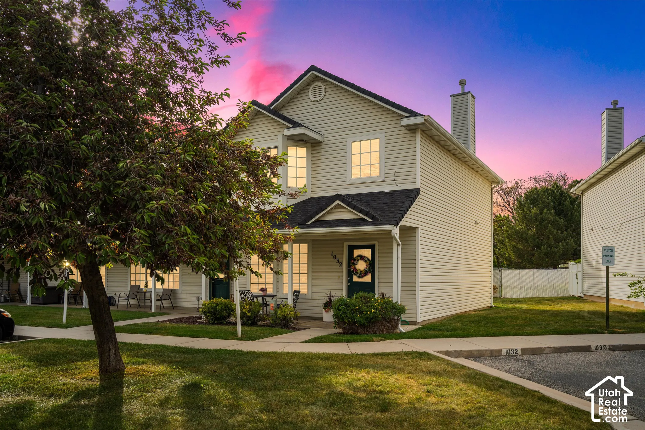 Two-story residence featuring light-colored siding, a dark shingle roof, and a covered front entry