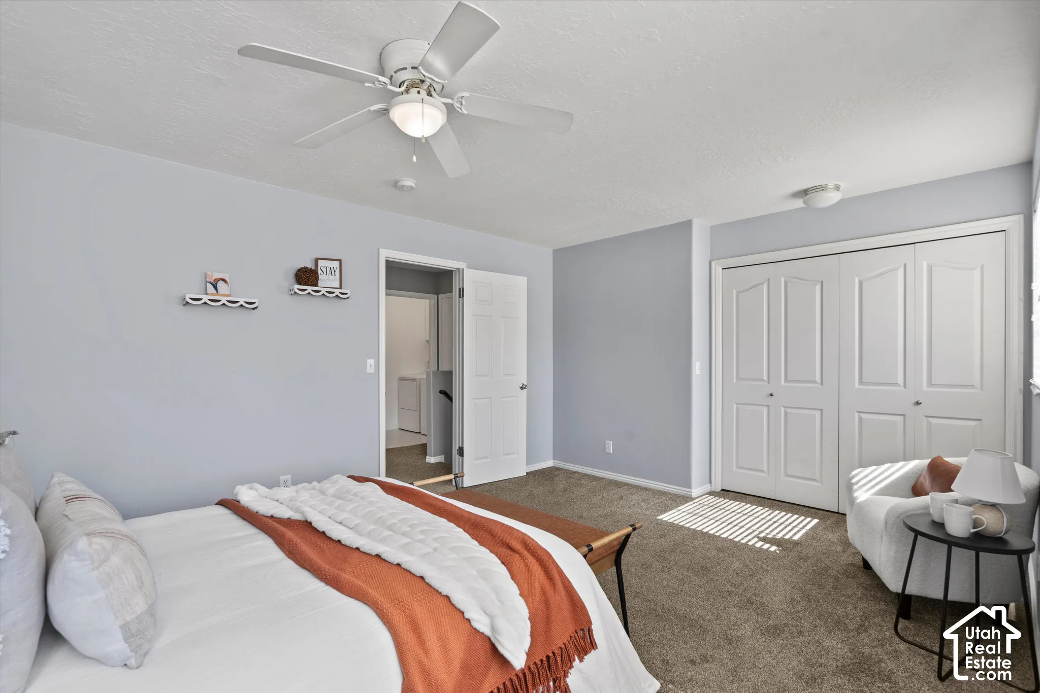 Room featuring a ceiling fan with integrated lighting, two bi-fold closet doors, and carpeting
