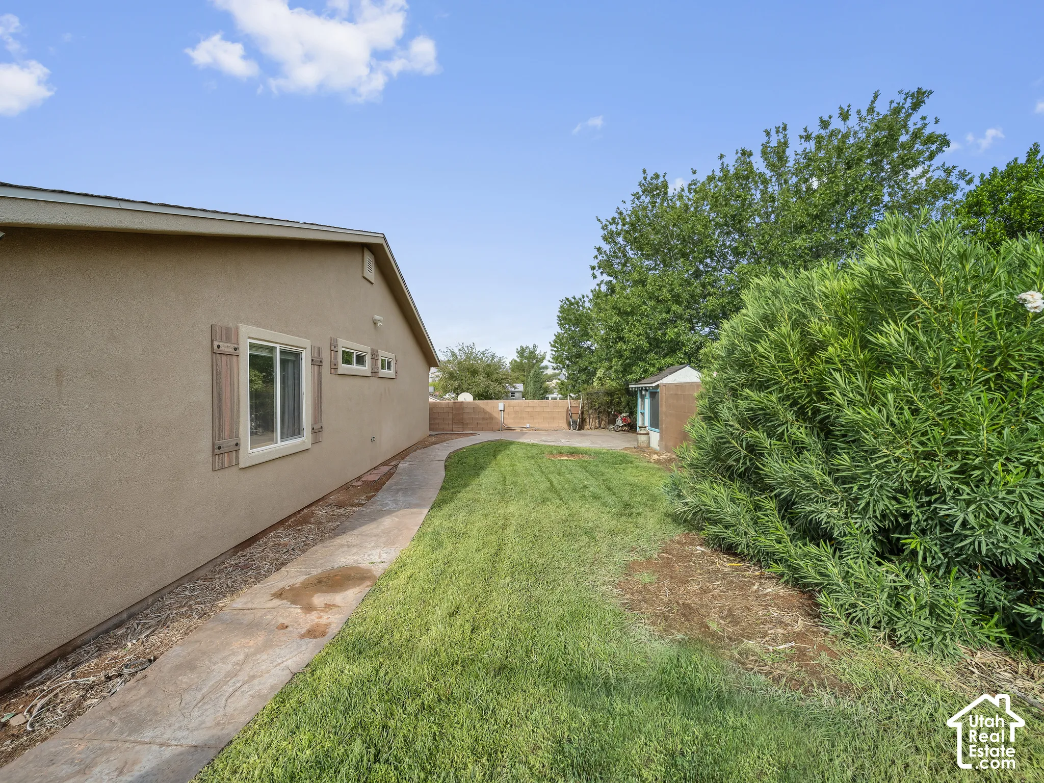 Expansive grassy area with a concrete pathway and mature landscaping