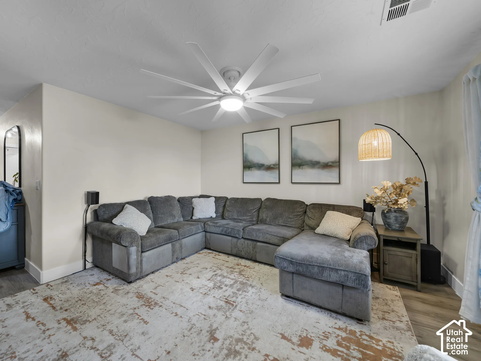 Recessed lighting, light wood-finish flooring, and a contemporary ceiling fan with integrated lighting