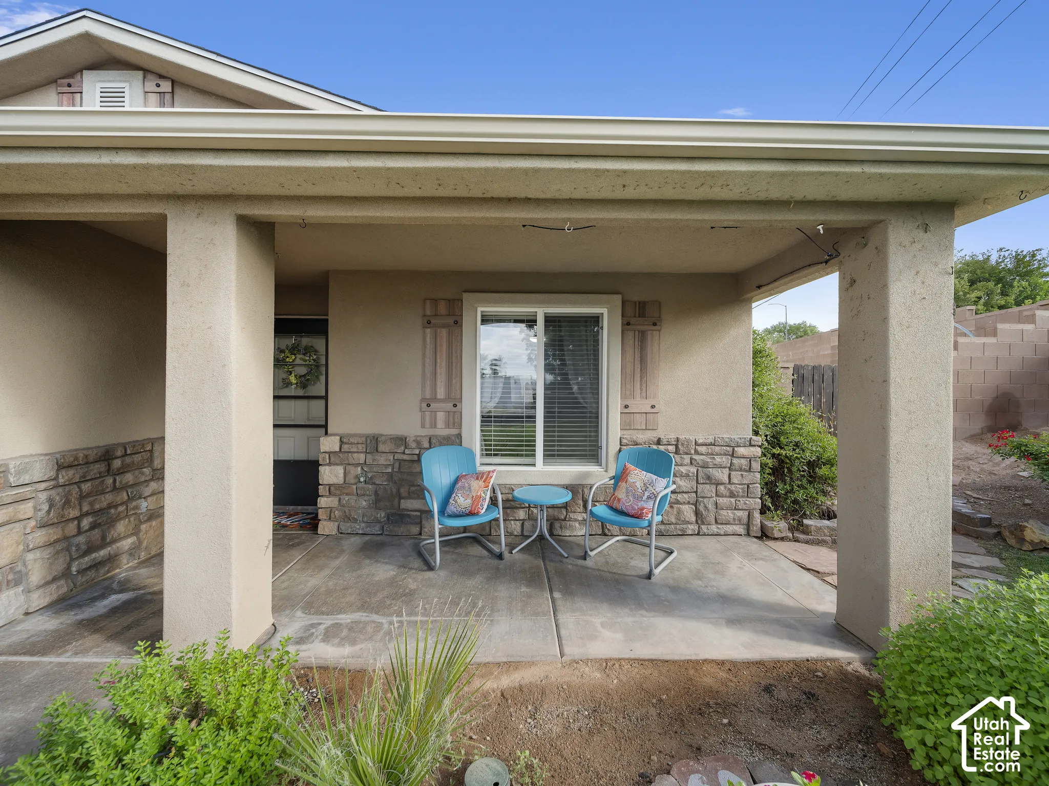 Covered front patio featuring stucco columns and stone-clad accents