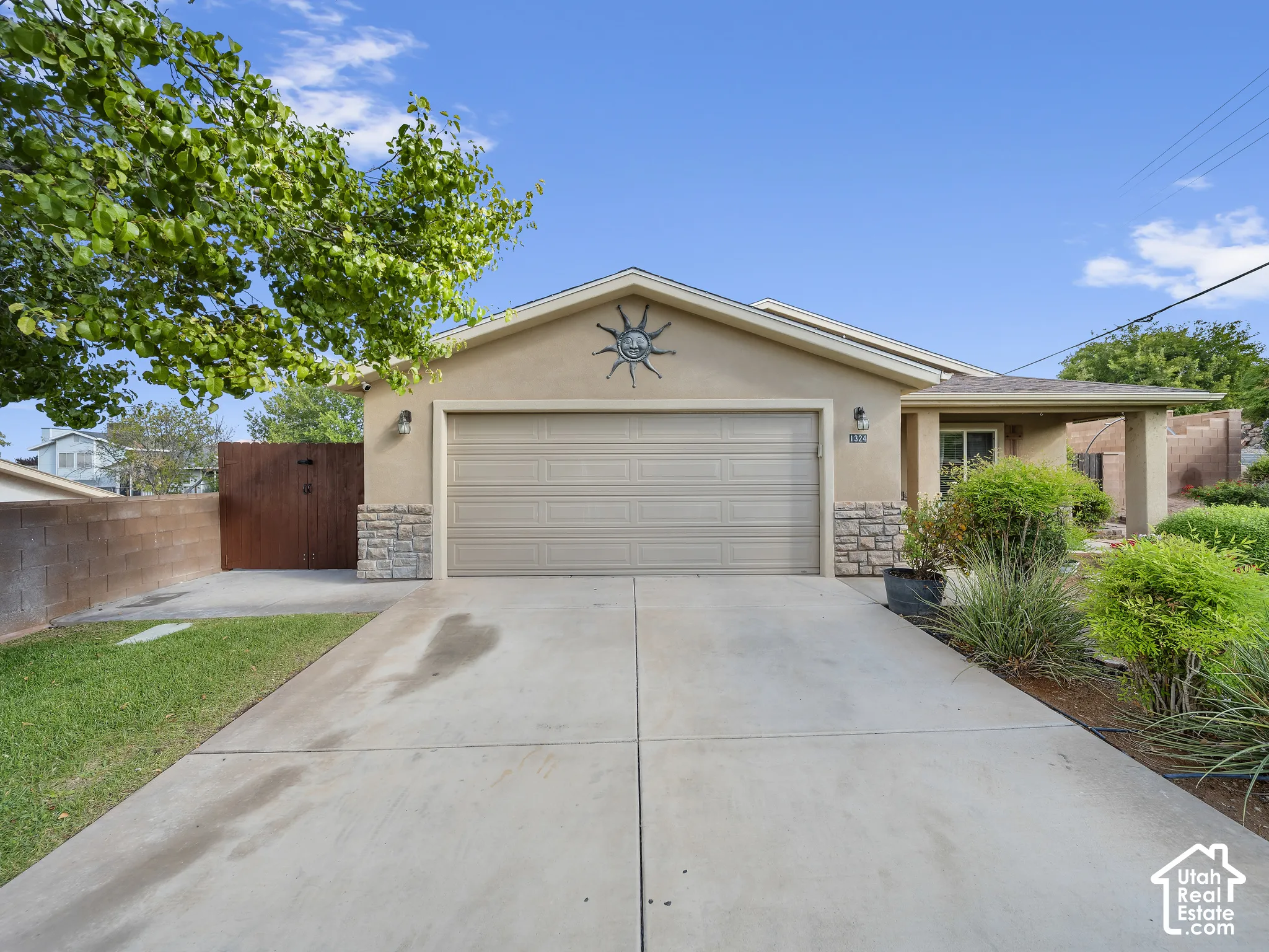 Stucco exterior with stone accents, covered entry, and an attached two-car garage